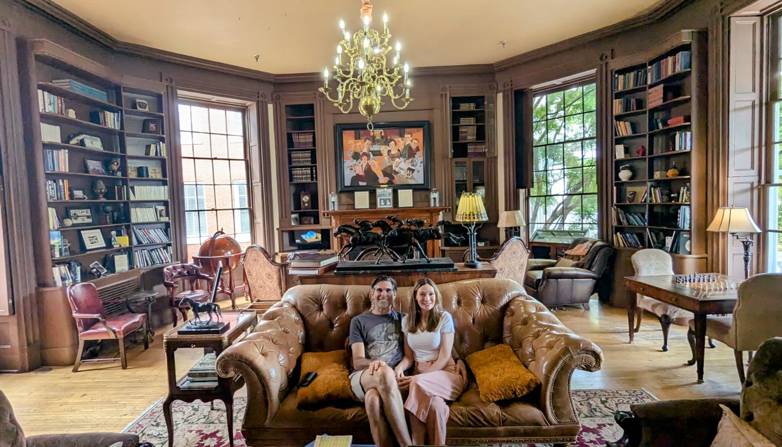 Luke Borgnis sitting on a sofa with his partner in a library